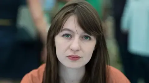 The acclaimed novelist claims she is unable to travel to the UK over arrest fears
